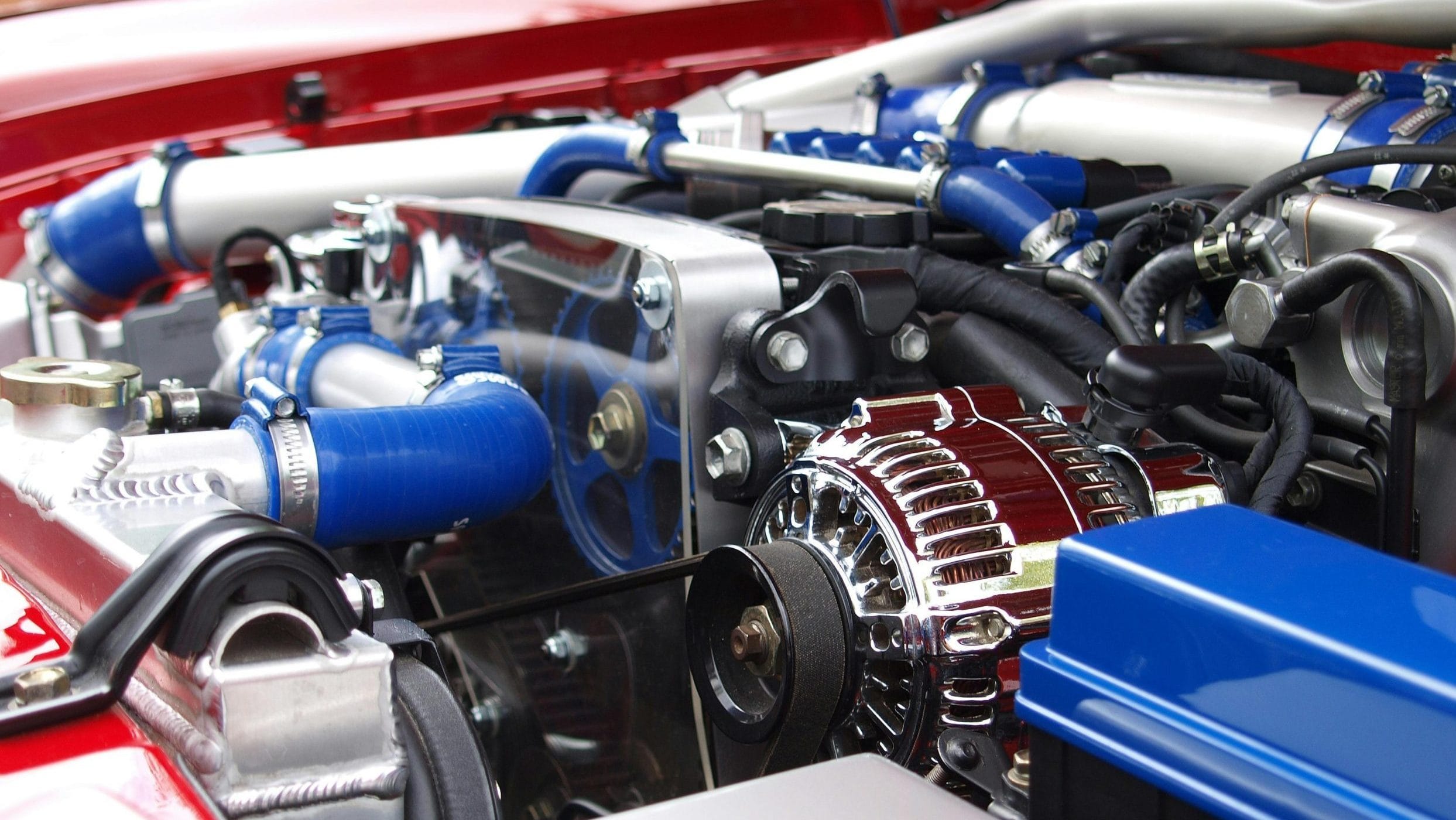 Detailed view of a clean modern car engine with vibrant colored components and sleek design.